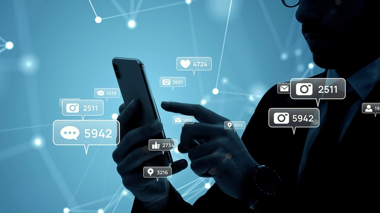 Man using cellphone with social media metric bubbles