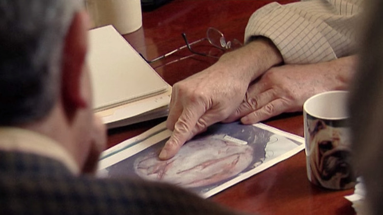 Examiners looking at autopsy photos