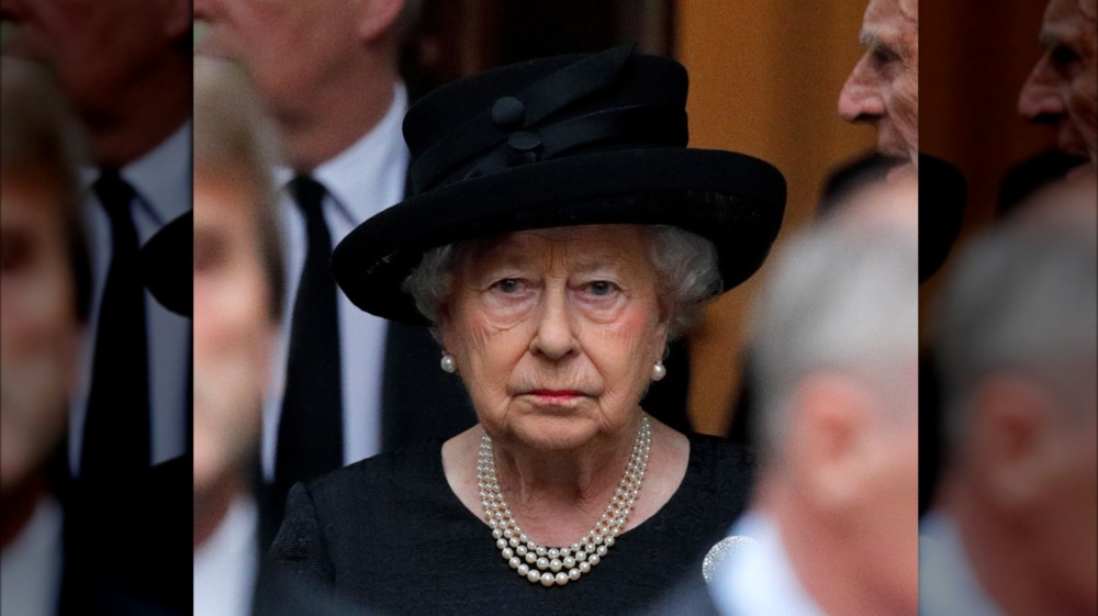 Queen Elizabeth wears a black outfit.