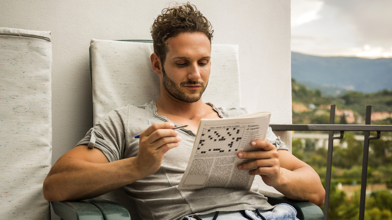 A man solving a crossword puzzle