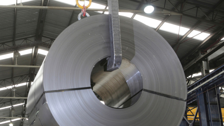 Coiled metal being hoisted inside a factory
