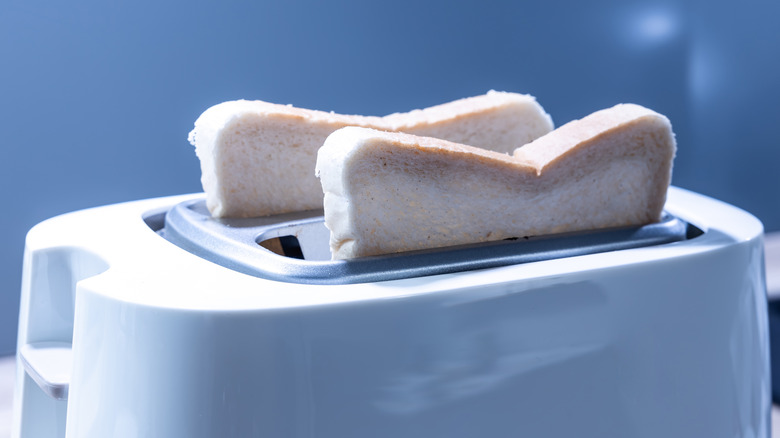 Two slices of bread inserted in a toaster