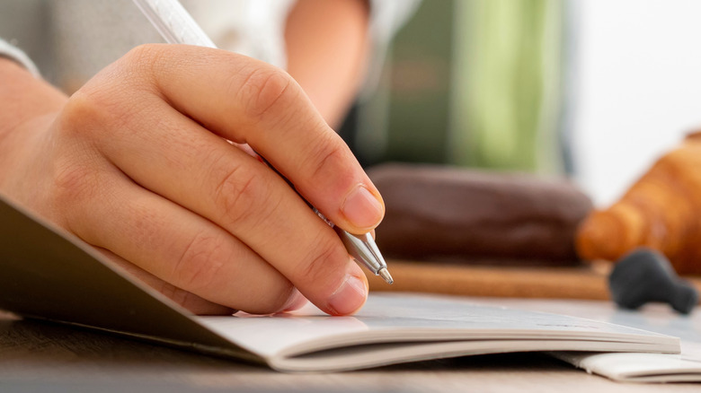 A hand writing with a pen