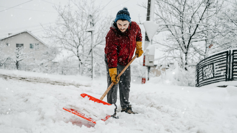 A man using a snow shovel during winter