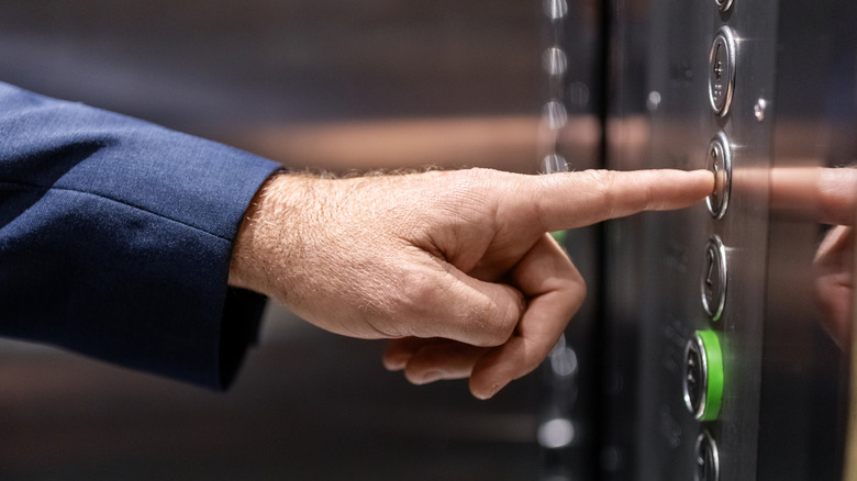 A person pressing an elevator button