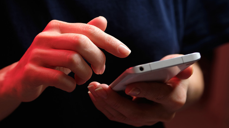 A person tapping their cellphone screen
