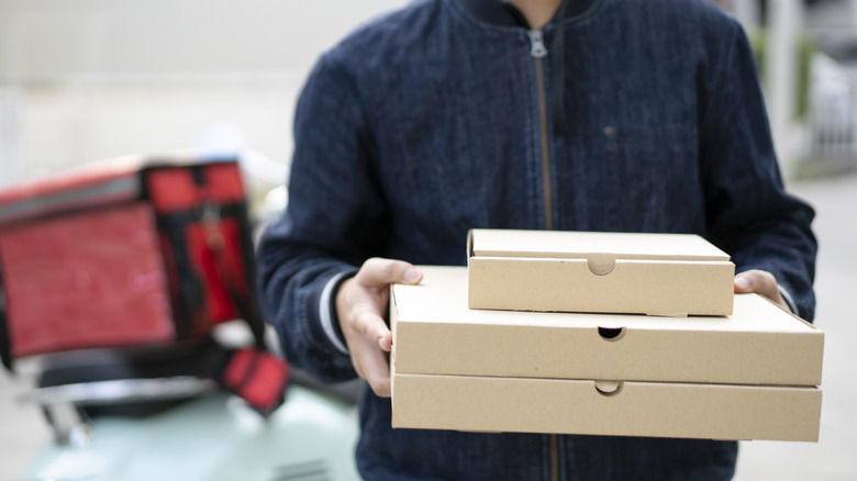 A man delivering pizzas