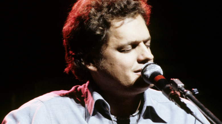 Harry Chapin singing and playing guitar with eyes closed