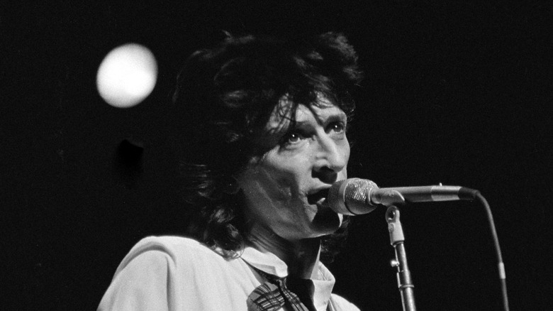 Johnny Thunders singing and playing guitar on stage