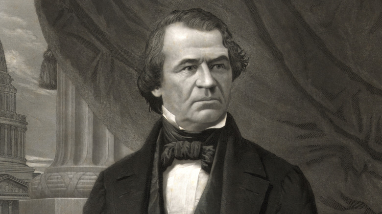 President Andrew Johnson in suit standing by window with view of the Capitol