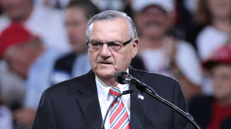Joe Arpaio in suit speaking at public rally