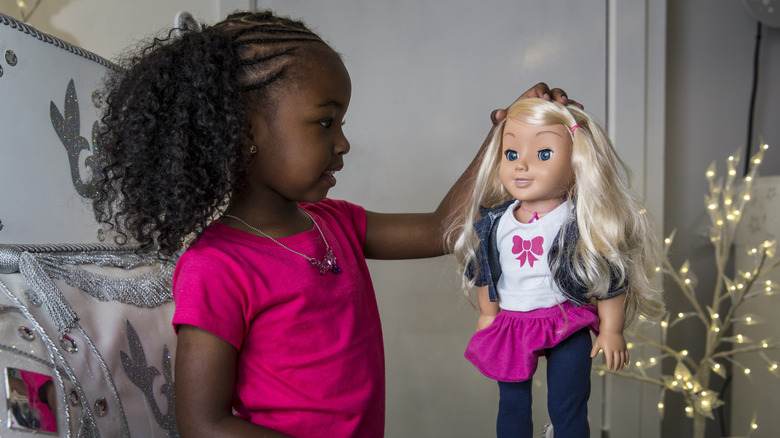 a girl plays with the subsequently recalled cayla doll