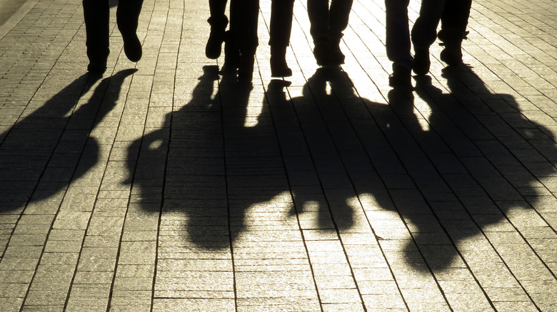 Ominous shadows of people walking