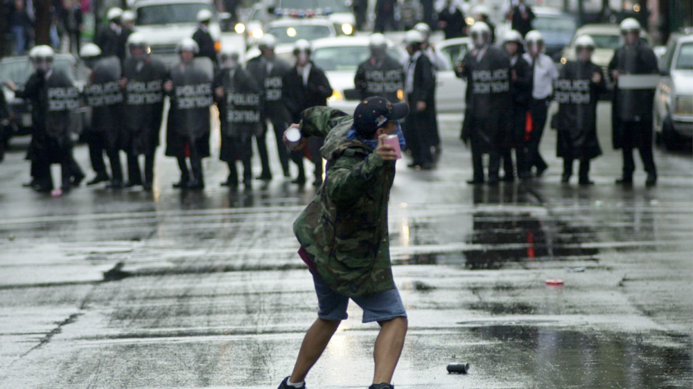 protester throwing garbage at police