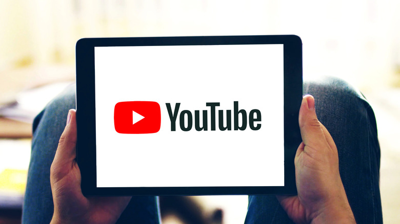  Holding tablet with YouTube logo 