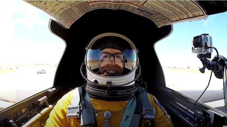 Adam in a plane wearing helmet