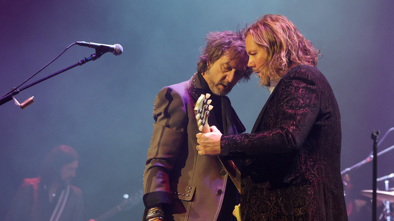 Chris and Rich Robinson of The Black Crowes stand close while performing on stage