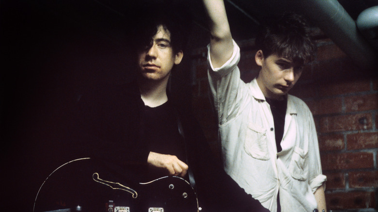 William and Jim Reid of The Jesus and Mary Chain looking very emo, posing with a guitar