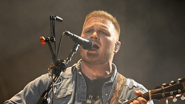Zach Bryan singing onstage