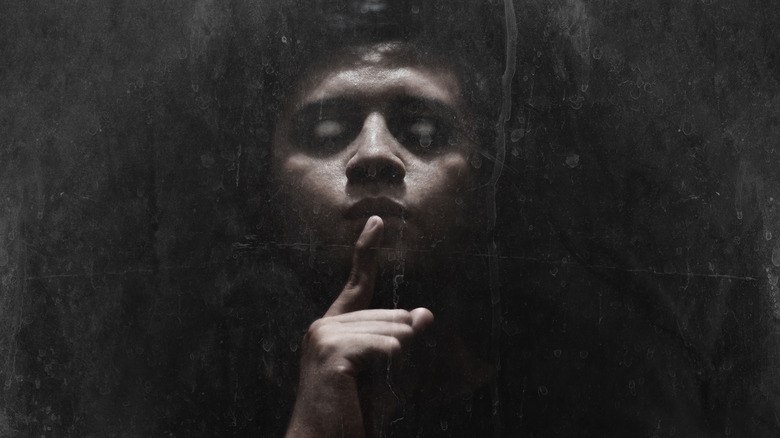 creepy face makes shush gesture