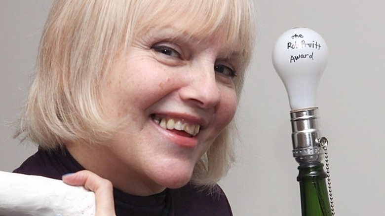 Cynthia Albritton smiling and holding one of her phallic casts