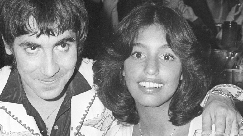 Lori Mattix smiles and posea for the camera, with Keith Moon's arm around her shoulder, black and white