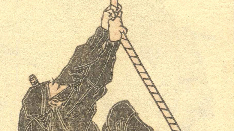 A ninja scales a wall rope