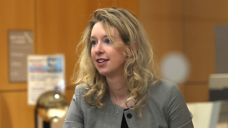 Elizabeth Holmes smiling in suit at court