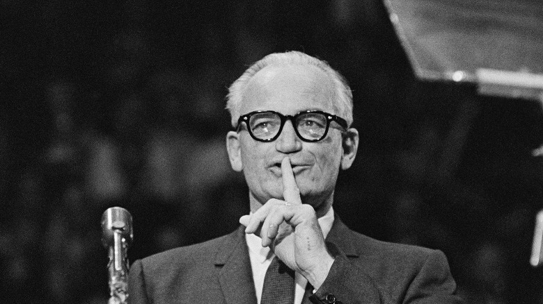 Barry Goldwater glasses holding finger to mouth
