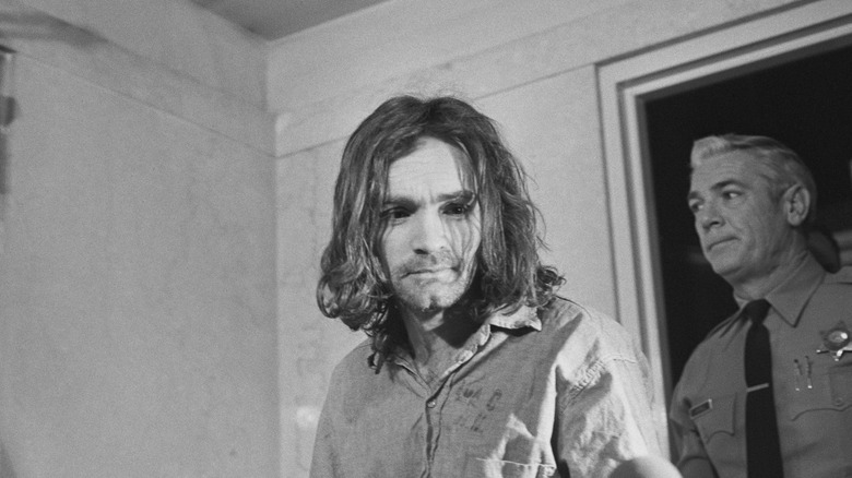Charles Manson escorted by police officer