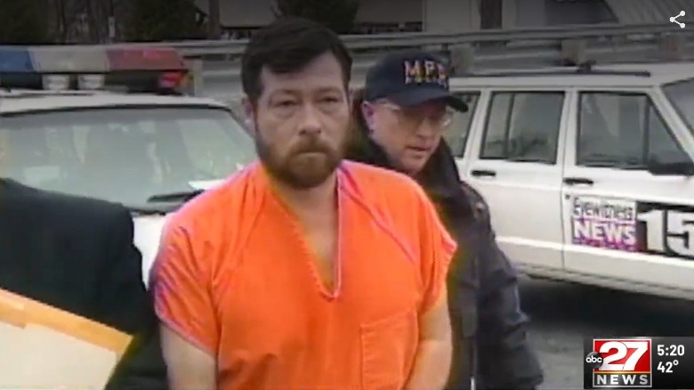 Wholaver in orange jumpsuit police escort