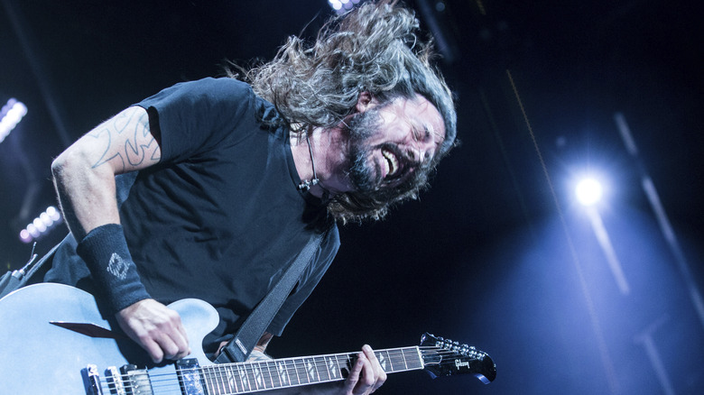 Dave Grohl on stage with guitar grimacing