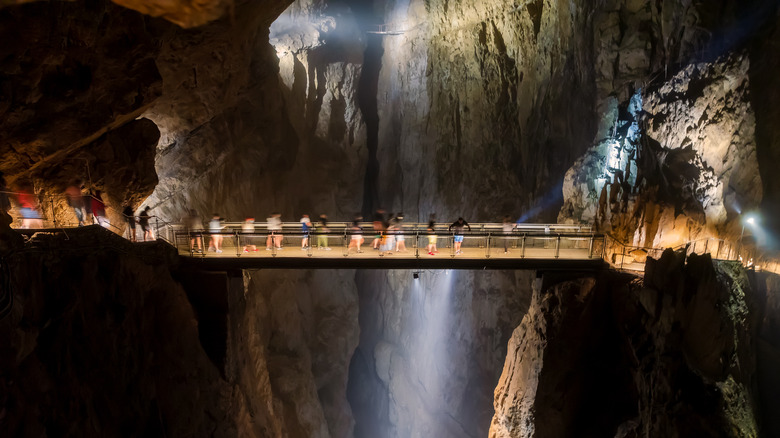 Skocjan Caves people crossing chasm on bridge