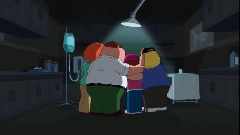 The Griffin family gathered around an operating table at a vet office