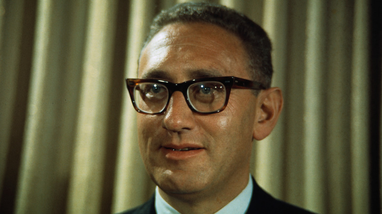 Then-National Security Advisor Henry Kissinger in front of a gold curtain