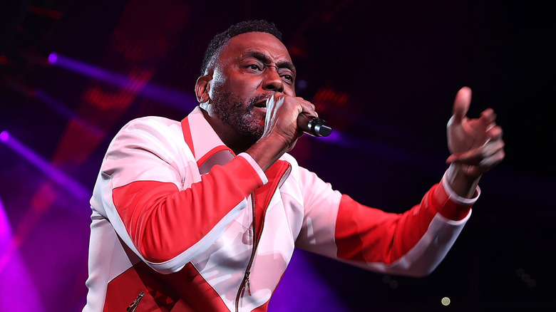 Big Daddy Kane performing mic white and red jacket