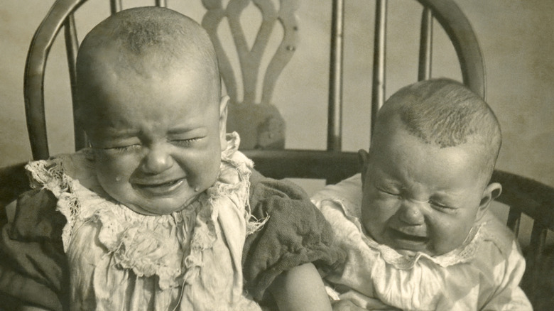 crying babies sitting in high chair