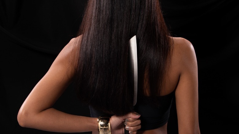 Woman with knife behind her back