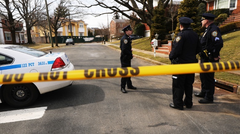 Police officers standing behind police tape