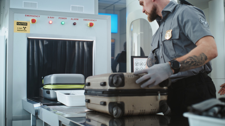 TSA worker scanning luggage at airport