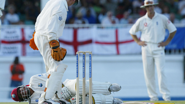 Cricket player laying ground fetal position 