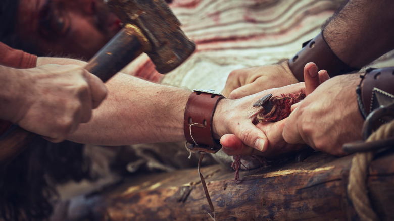 Nailing hands and feet during crucifixion
