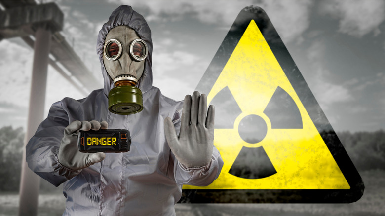 radiation danger warning sign with person in hazmat suit