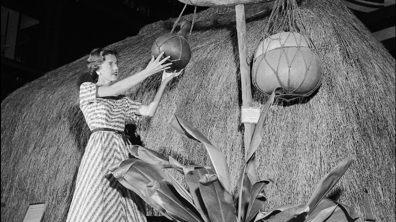 Woman holding object outside hut