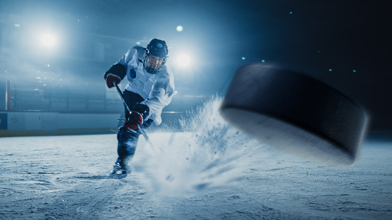 Ice hockey player strikes puck 