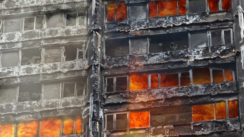 A close up of several charred floors of Grenfell Tower still burning