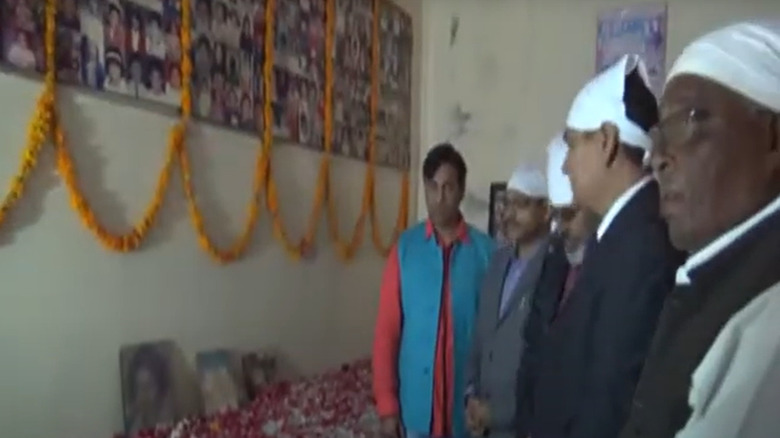 Men looking at images of victims of the 1995 Dabwali fire during a 20th anniversary memorial