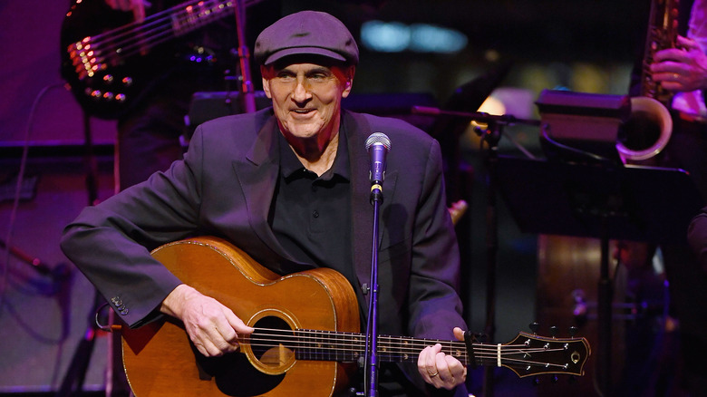 James Taylor on stage playing guitar