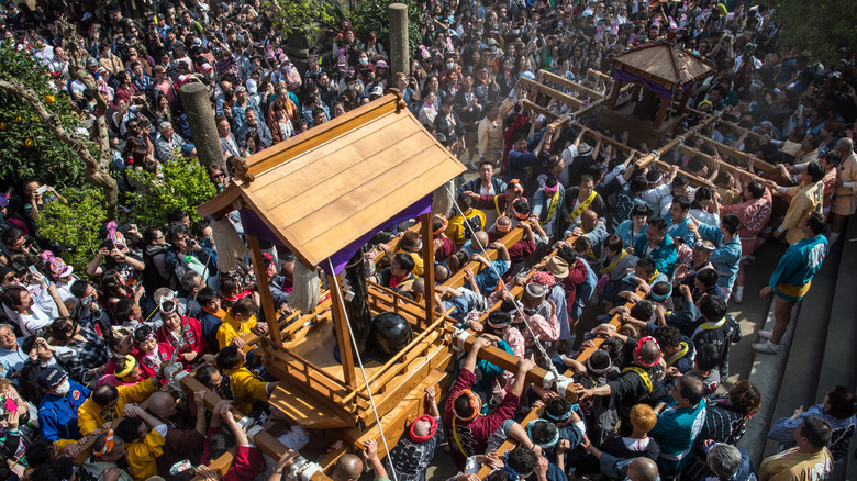 Phallic statue is carried on a shrine
