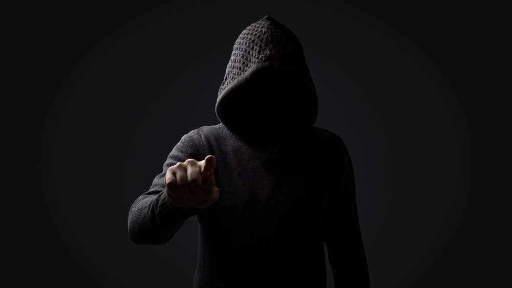 threatening figure wearing black hood